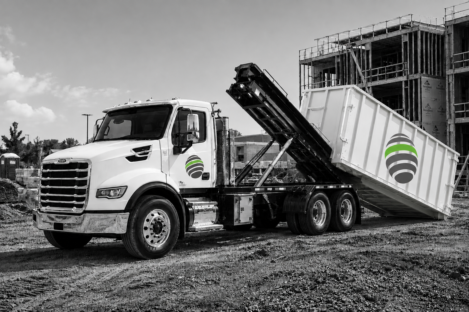 Green Halo branded roll-off truck delivering a white debris box at a construction site